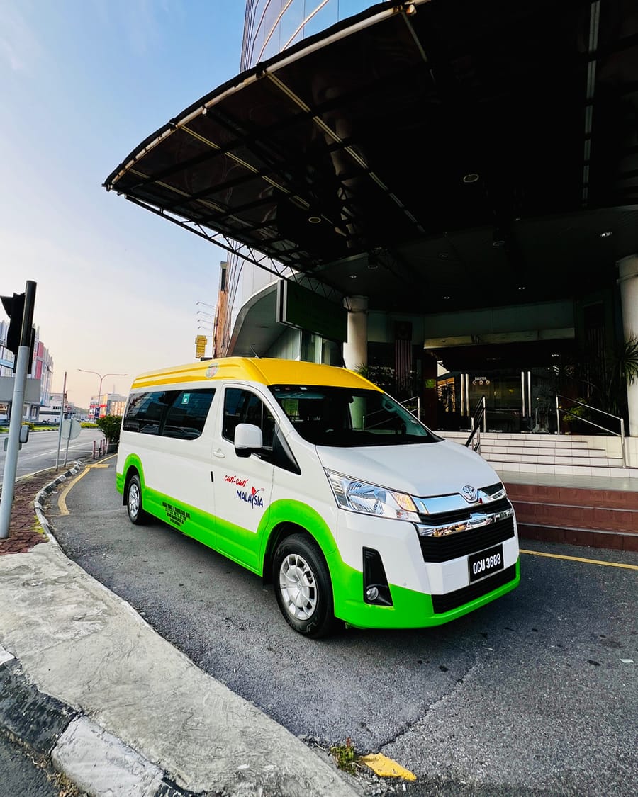 INSAR 10 seater tour van at a hotel entrance in Kuching