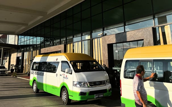 INSAR tour vans on a hotel forecourt in Kuching at the end of the day